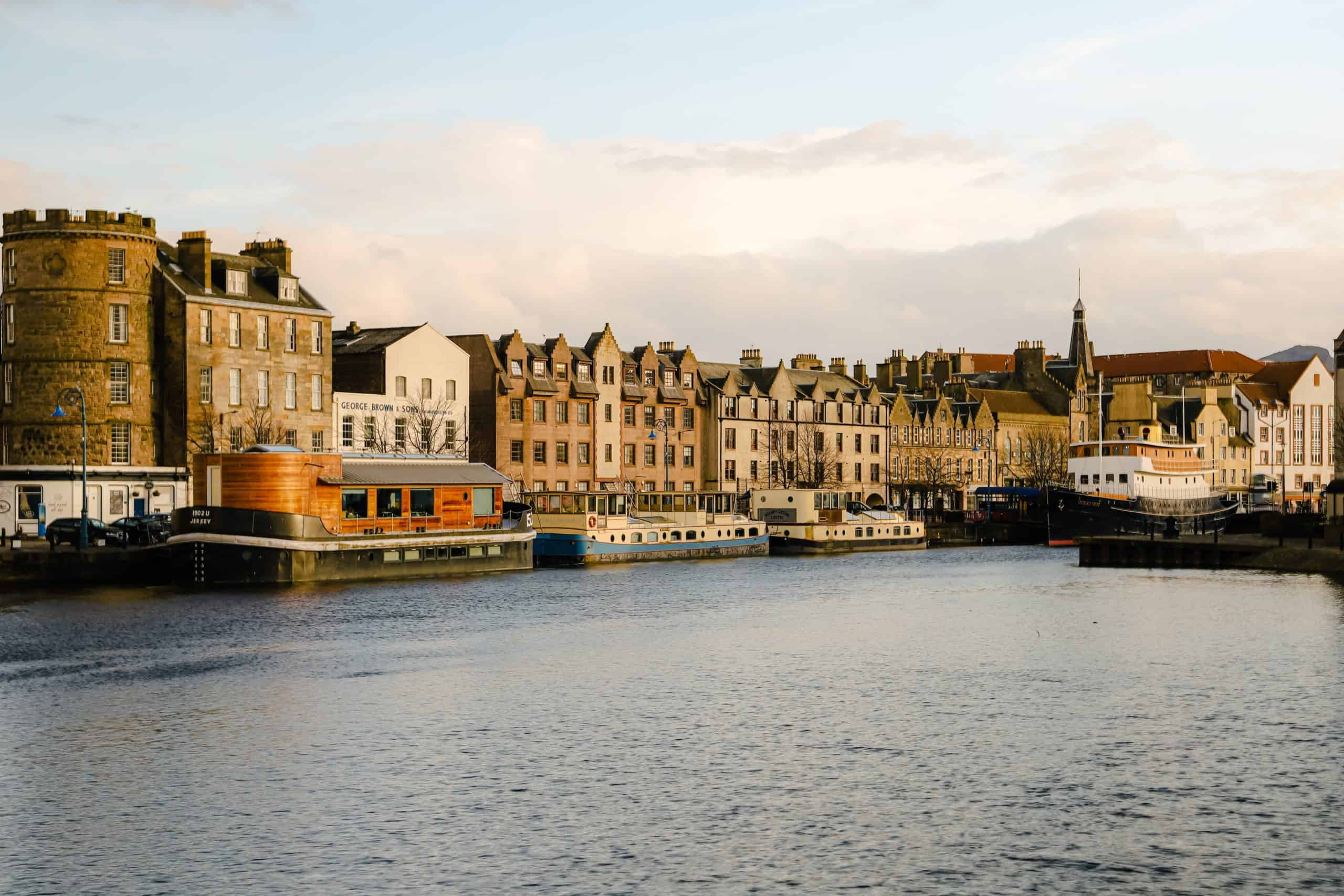 The Water of Leith and docks area with multiple boats that function as hotels or restaurants. on the water.