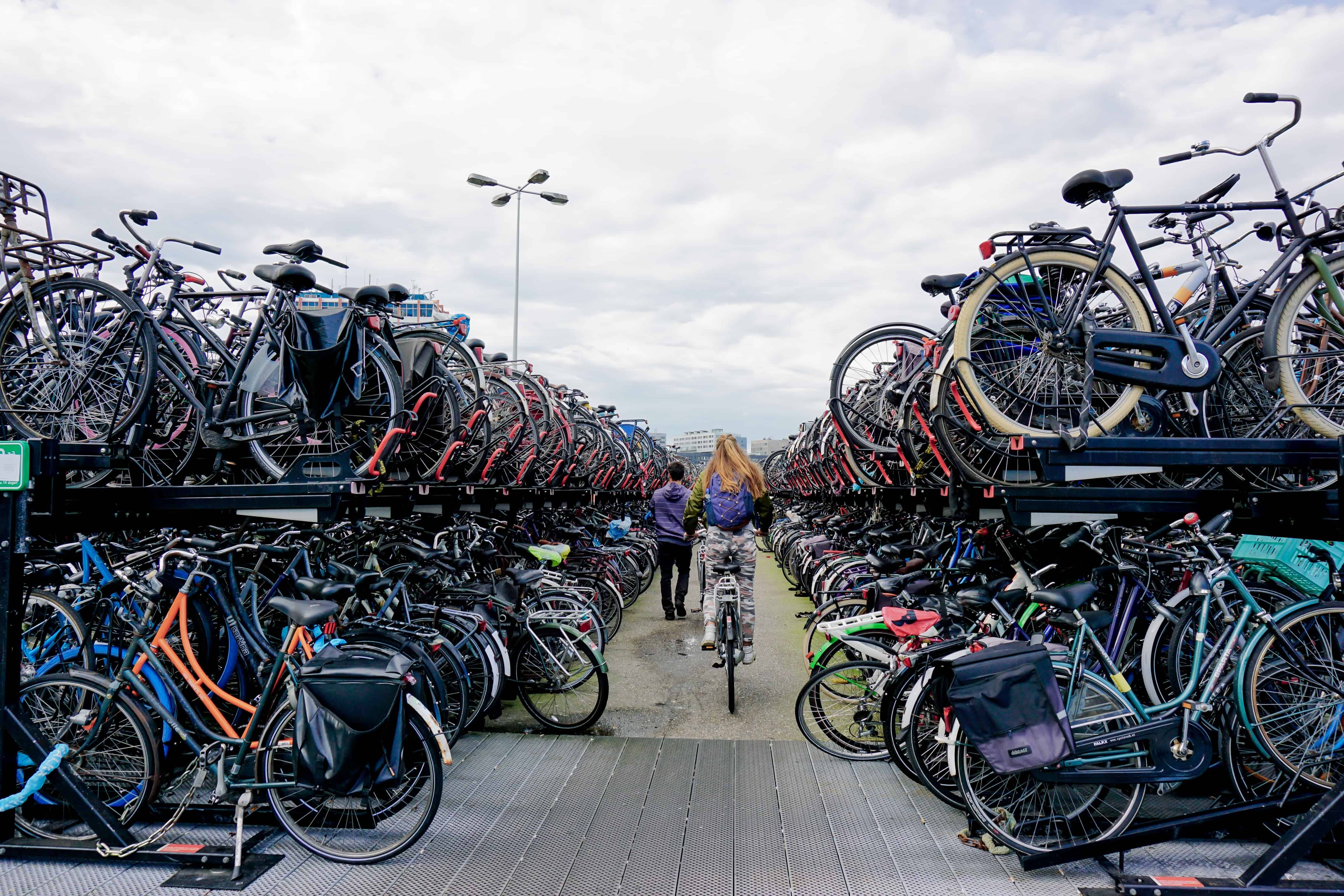 A two story bike parking lot in the Netherlands with hundreds of bikes on a first and second level.