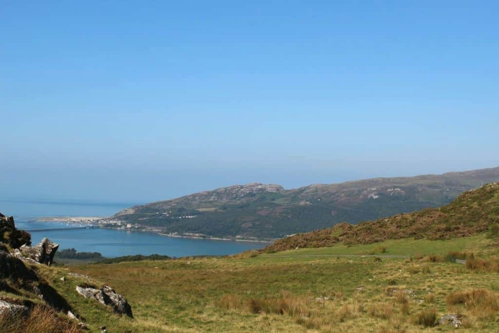 A view of North Wales that shows green pastures and the sea in the background.