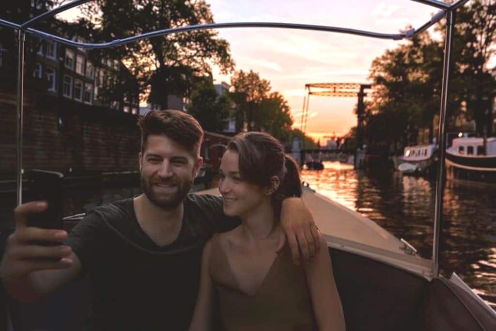 A couple on a romantic, private canal cruise taking a selfie.