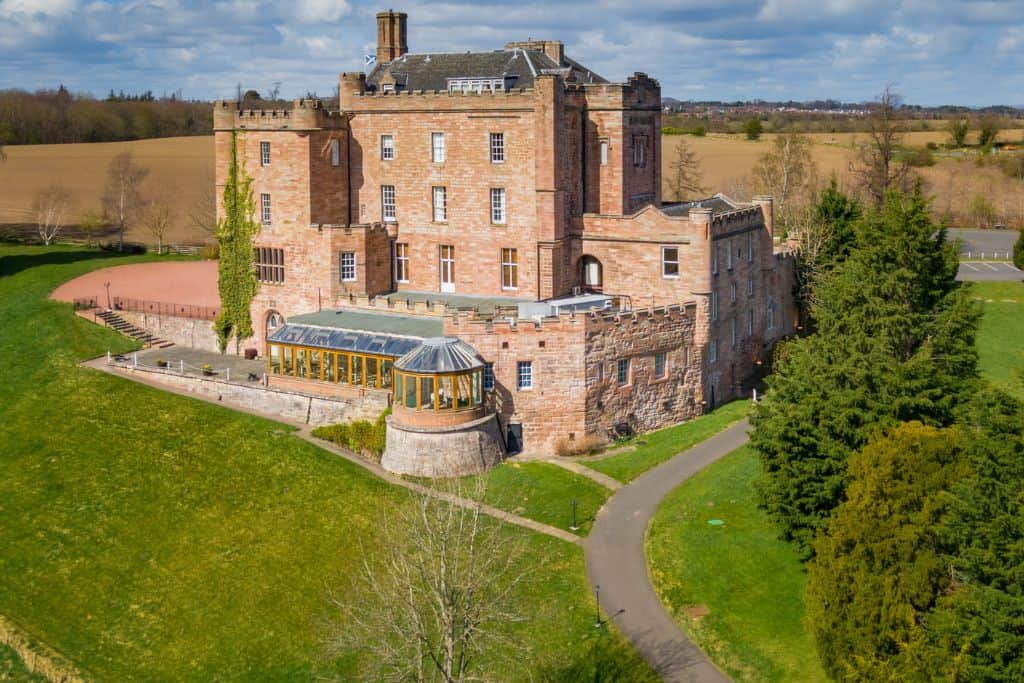 Best Edinburgh Hotels With Spa Dalhousie Castle, one of the best spa hotels in Edinburgh, as seen from above on a spring day.