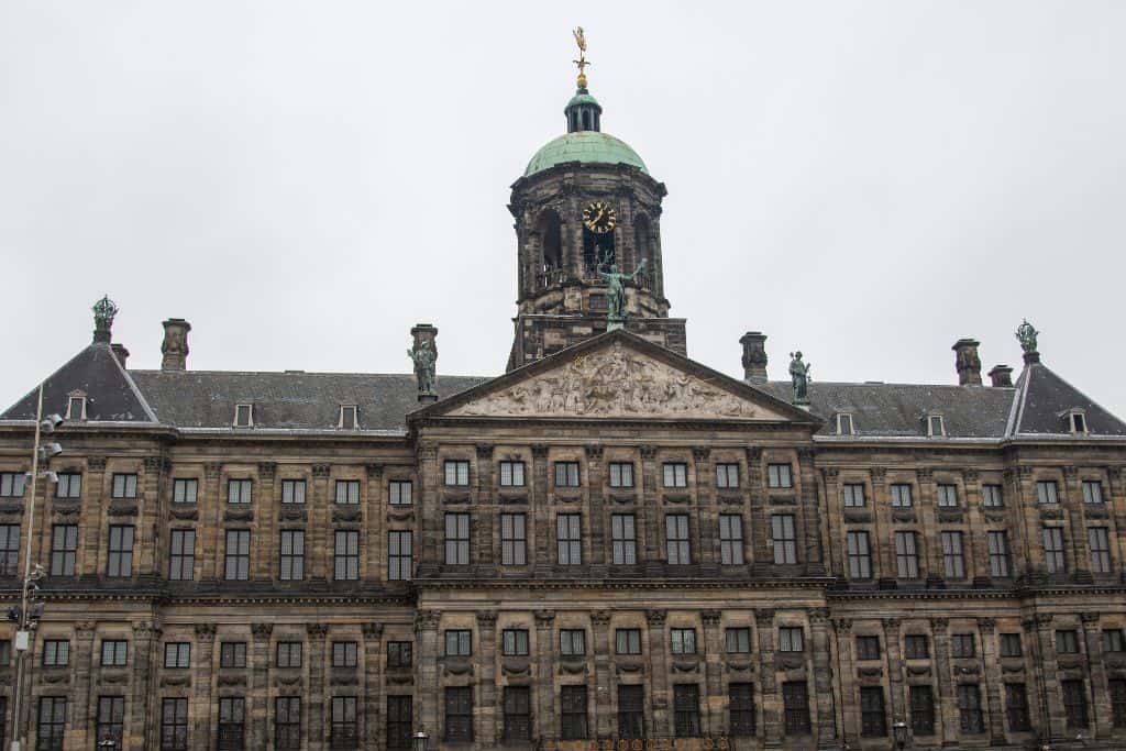 Amsterdam Central Station The main central train station in Amsterdam from the front showing the clock tower and many windows.