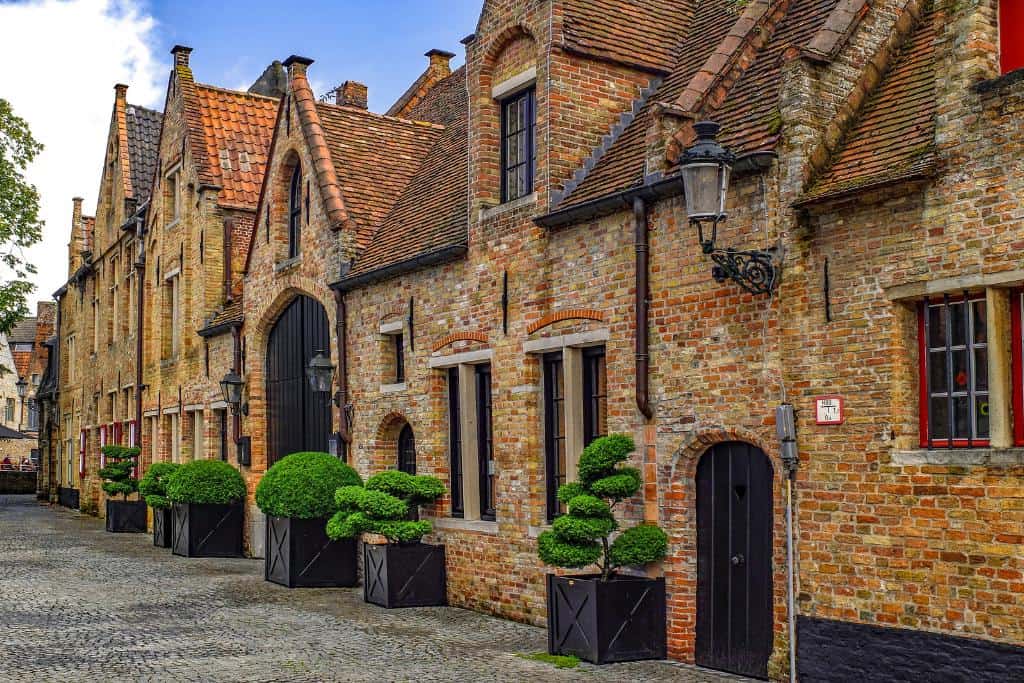 Is Bruges Worth Visiting? Attached homes along the lovely sidewalks in Bruges. The quaint house facades in Bruges make it worth visiting.