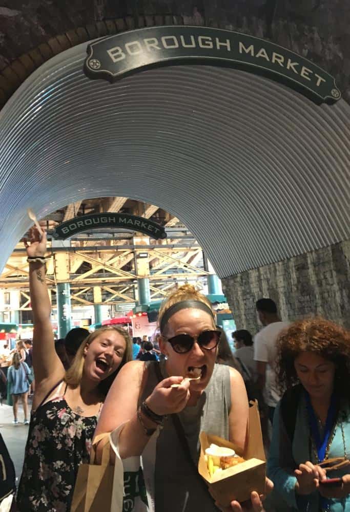 What is London Famous For Taylor eating fish and chips at the Borough Market while walking through the Borough Market entrance.