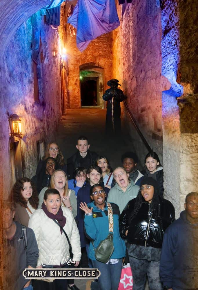 Famous-Streets-in-Edinburgh The narrow alleys in Mary King's Close make for a great experience. A group of people taking a tour which takes place in the alleys of Edinburgh.