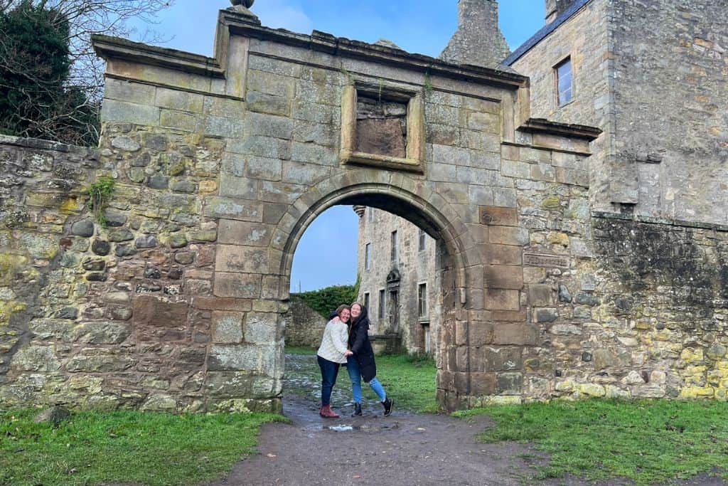 Day Trips From Edinburgh Without a Car Taylor and her friend standing in the arch of the entry at Midhope Castle, also known as Lallybroch in the Outlander television series.