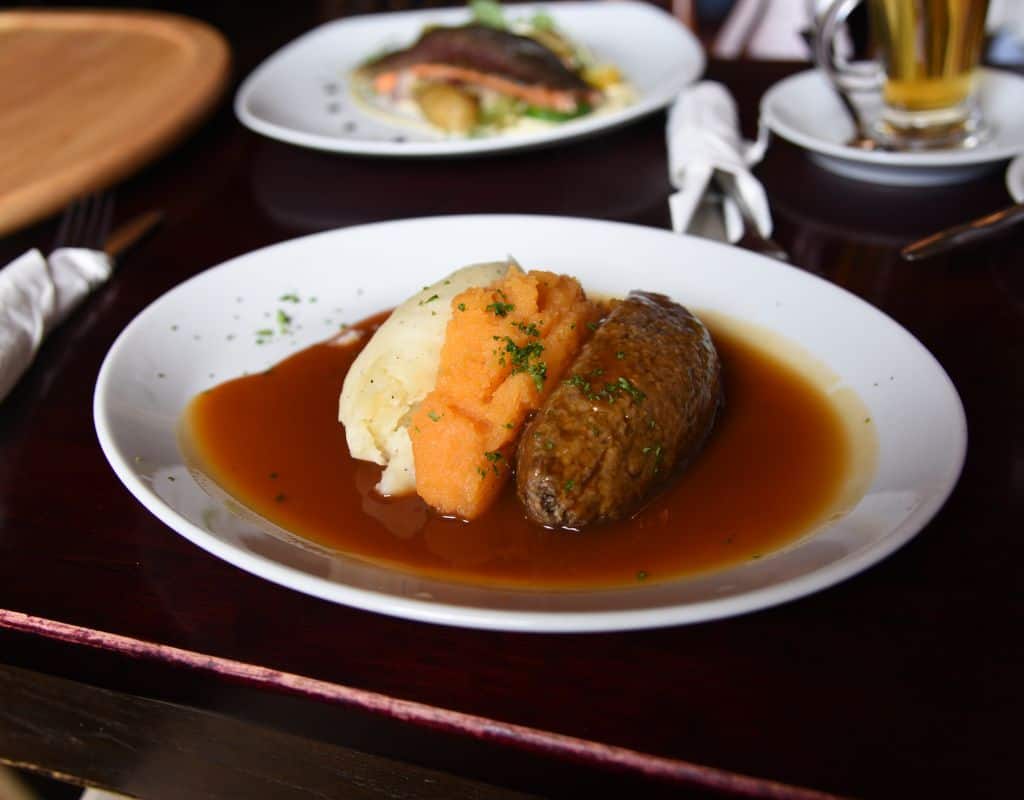A quintessential Scottish dish of haggis, neeps, and tatties, served with a flavorful gravy, a must-try on one of the best food tours in Edinburgh.