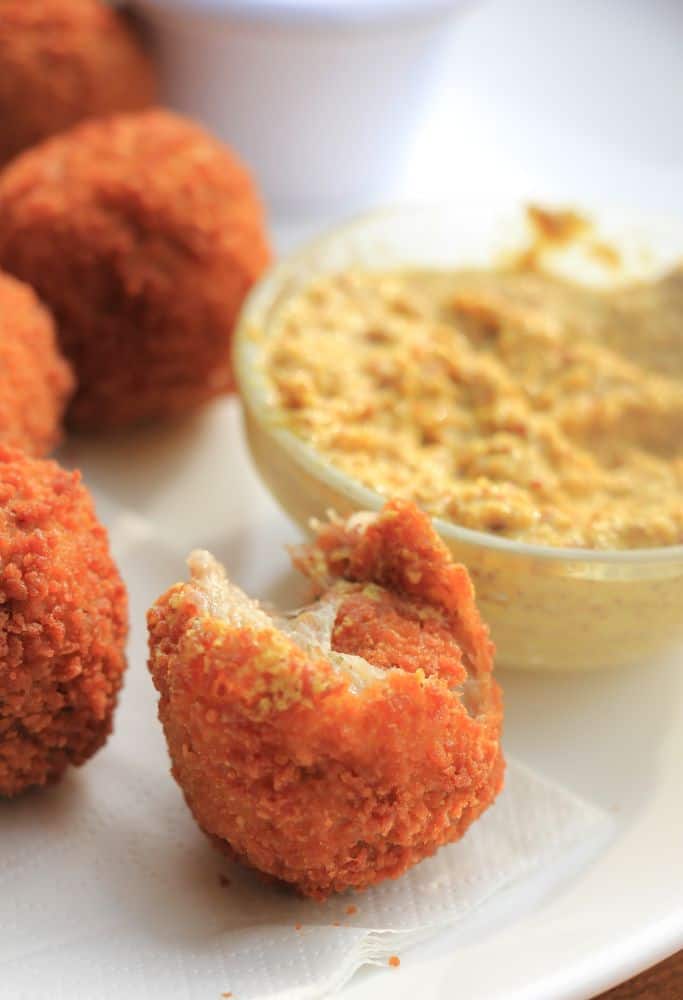 A close-up of Dutch bitterballen, crispy fried meat-filled snacks, with a crunchy golden coating and served with a side of mustard sauce – a must-try item when considering what to eat in Amsterdam.