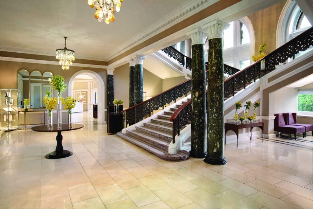 Historic Hotels in Edinburgh A large, sweeping marble staircase leading down into the marble-floored lobby at the Waldorf Astoria Edinburgh- The Caledonian.