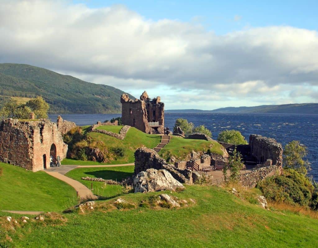 Ruins of Urquhart Castle sit beside the deep blue waters of Loch Ness in the Scottish Highlands, a historic site that often makes visitors wonder, “Is Scotland in Ireland?” due to their shared Celtic heritage.