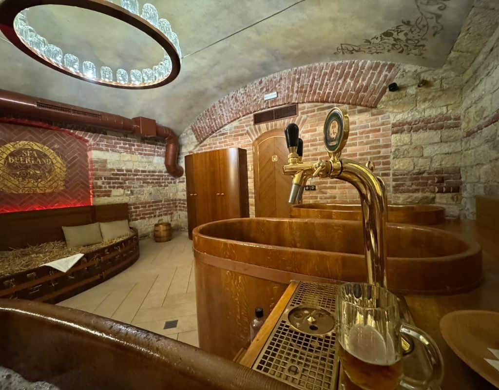 Rustic beer spa room with wooden soaking tubs, exposed brick walls, and a draft beer tap creating a unique wellness experience in Prague during 3 Days in Prague.