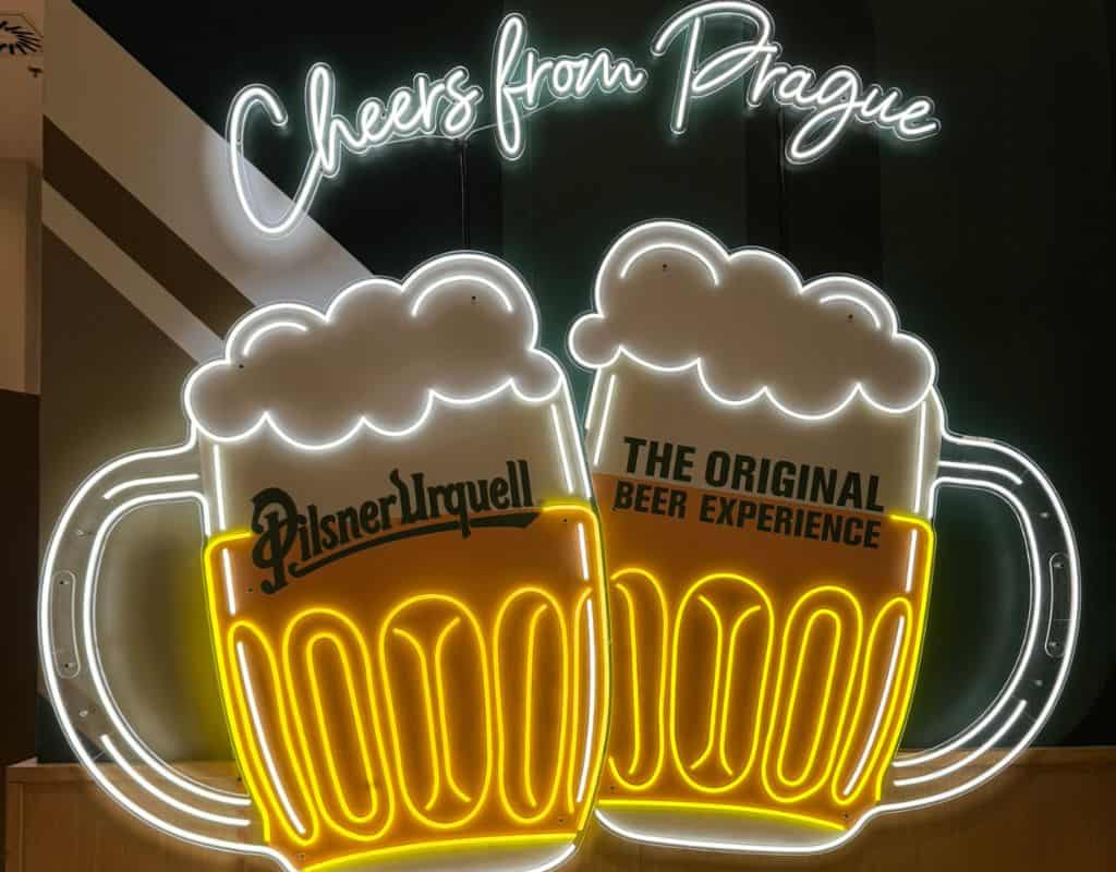 Bright neon beer mug display reading “Cheers from Prague” inside the Pilsner Urquell Beer Experience during 3 Days in Prague.